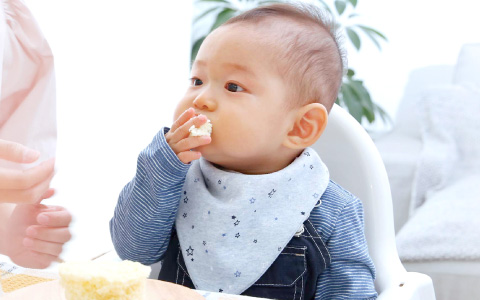 手づかみで、レンジで蒸しパンを食べている様子